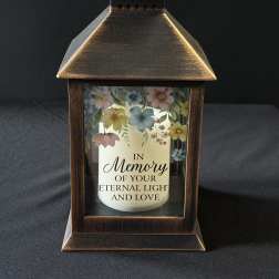 Bronze lantern with a memorial candle and pastel floral print