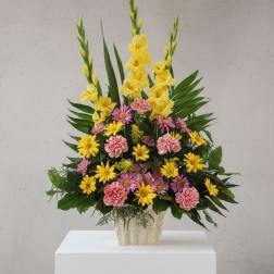 Mixed yellow and pink flowers in a beige vase