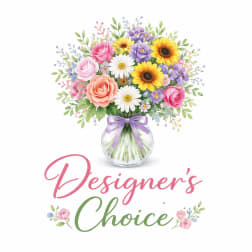 Mixed bouquet of roses, daisies, and sunflowers in a glass vase with a ribbon