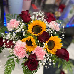 Bouquet of sunflowers, red roses, and pink carnations with baby's breath