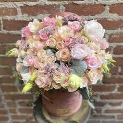 Round bouquet of blush pink and cream roses in a pink hatbox