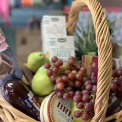 Gift basket with pears, grapes, and packaged snacks