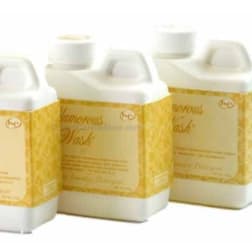 Three white plastic bottles with gold labels