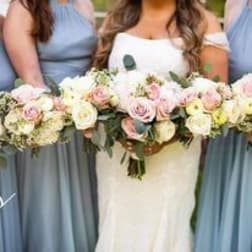 Bridesmaids holding pastel rose bouquets