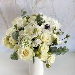 White rose bouquet in a white vase with eucalyptus
