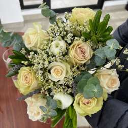 Bouquet of cream roses with small white filler flowers and eucalyptus
