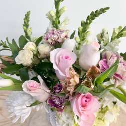 Mixed bouquet of pink and white flowers in a white vase