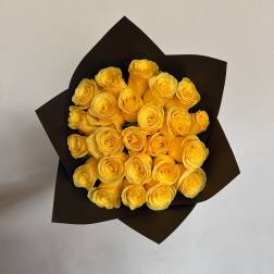 Bouquet of yellow roses wrapped in dark paper
