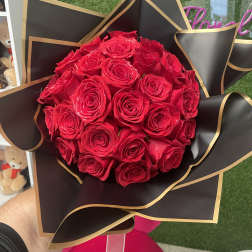 Bouquet of red roses wrapped in black paper with gold trim