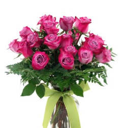 Pink roses arranged in a clear glass vase with a green ribbon