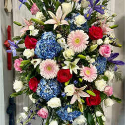 Tall standing floral spray with roses, lilies, hydrangeas, and gerbera daisies