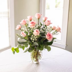 Pink roses arranged in a clear glass vase