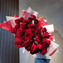 Large bouquet of red roses wrapped in red and white paper