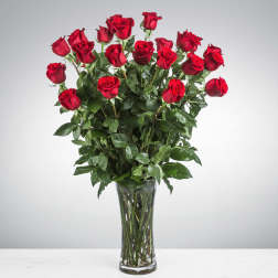 Tall bouquet of red roses in a clear glass vase