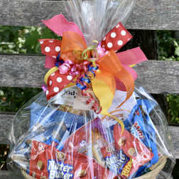 Basket of assorted snack packs wrapped in clear cellophane with colorful ribbon