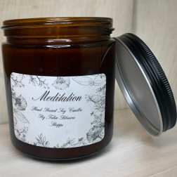 Amber jar candle with a floral label and black lid