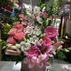 Pink and white mixed flower arrangement in a box with a pink ribbon