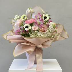 Bouquet of pink and white flowers wrapped in blush paper