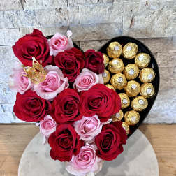 Heart-shaped box with red and pink roses and gold-wrapped chocolates