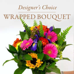 Wrapped bouquet of mixed bright flowers held in a gloved hand