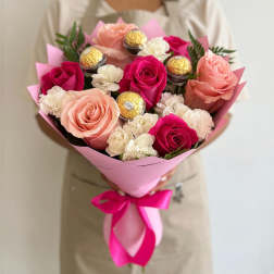 Bouquet of pink and peach roses with white carnations and gold-wrapped chocolates