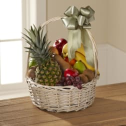 Wicker basket filled with assorted fruit and topped with a ribbon bow