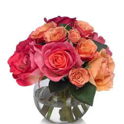Pink and peach roses arranged in a clear glass vase