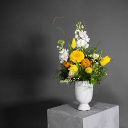 Yellow and white floral arrangement in a white vase