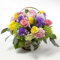 Basket arrangement of pink, yellow, and purple flowers
