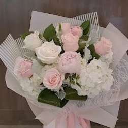 Bouquet of pink and white roses with hydrangeas wrapped in white paper