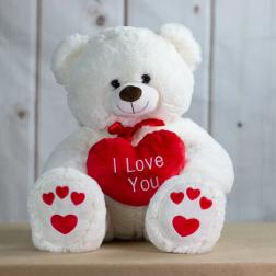 White teddy bear holding a red heart that says I Love You