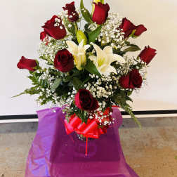Bouquet of red roses and white lilies in a glass vase