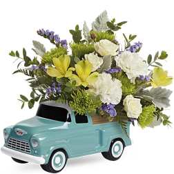Teal toy truck filled with white and yellow flowers
