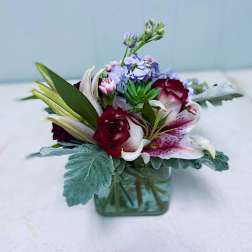 Mixed bouquet in a square glass vase with roses and lilies