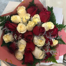 Bouquet of red and cream roses wrapped in pink paper
