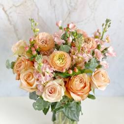 Peach and blush rose bouquet in a clear glass vase