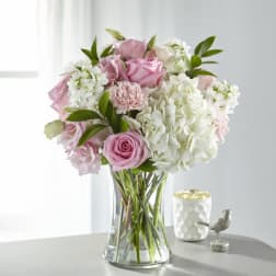 Pink and white bouquet of roses and hydrangeas in a clear glass vase