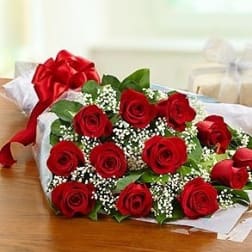 Bouquet of red roses with baby's breath wrapped in white paper