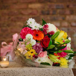 Mixed bouquet of colorful flowers wrapped in clear plastic