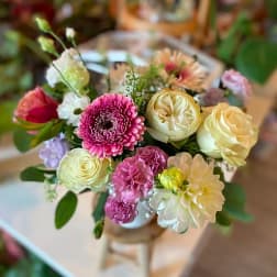 Bouquet of pink, cream, and yellow flowers in a vase