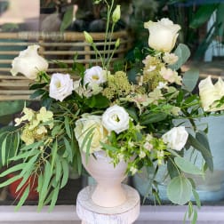 White roses and small white blooms in a pale vase