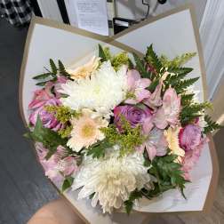 Bouquet of pink and white flowers wrapped in white paper