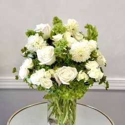 White roses and dahlias arranged in a clear glass vase