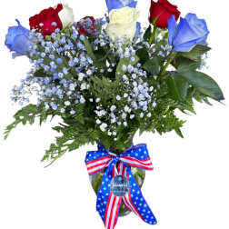 Bouquet of red, white, and blue roses in a glass vase with a patriotic ribbon