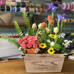 Mixed bouquet with tulips, irises, roses, and daisies in a wooden box