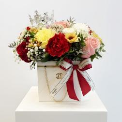 Mixed bouquet of roses and carnations in a decorated gift box