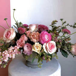 Pink and cream rose arrangement in a gray vase