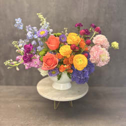 Colorful mixed bouquet in a white pedestal vase