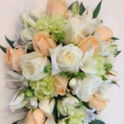 Cascade bouquet of peach and white roses with white lilies