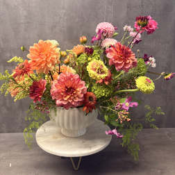 Colorful mixed bouquet of dahlias in a white vase